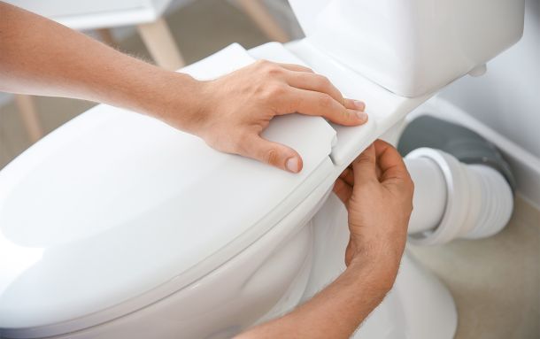 Photo of plumber installing toilet Scotia Plumbing toilet installation